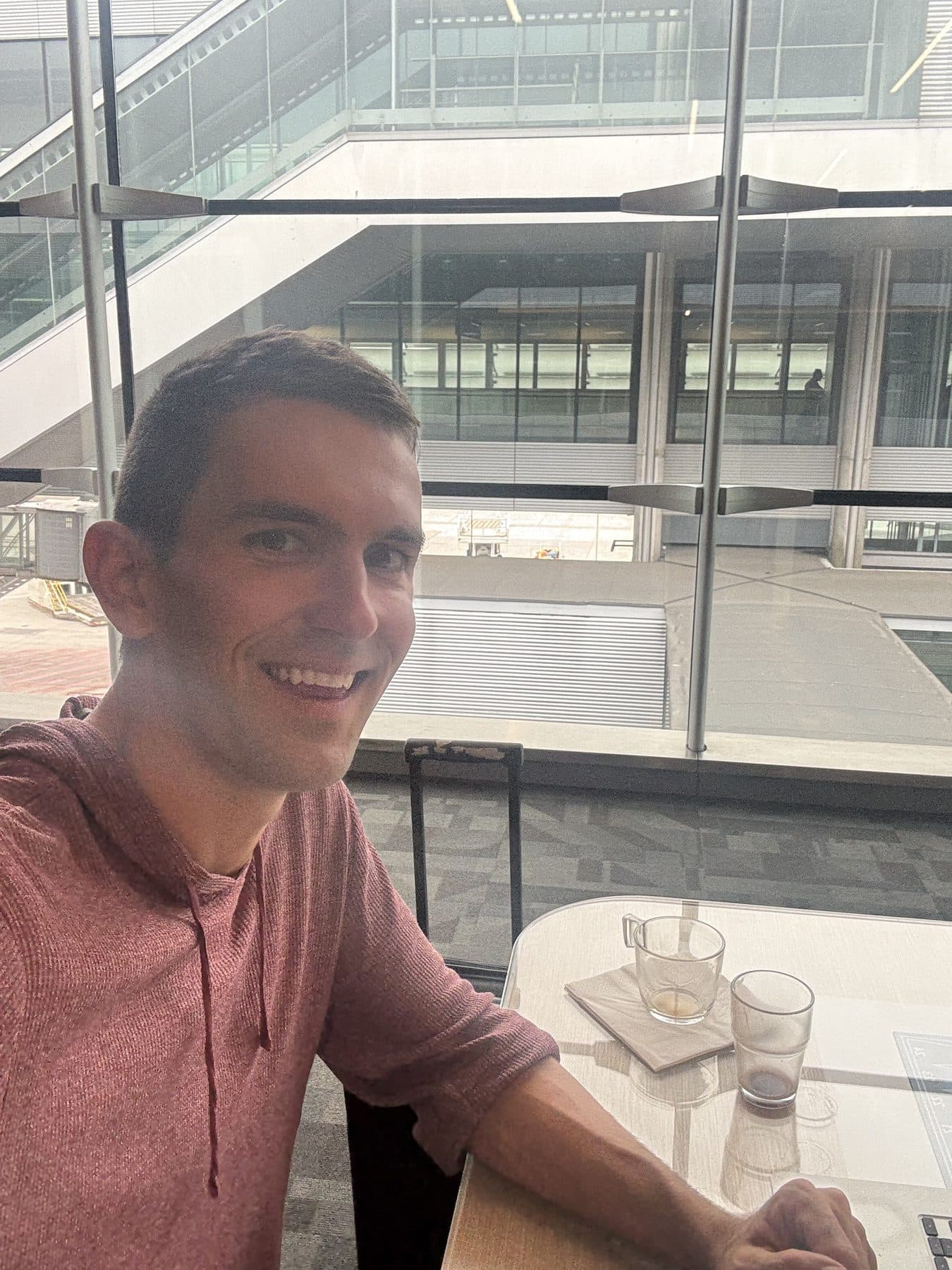 Jon Miksis working at a window seat in an airport lounge at Paris Charles de Gaulle