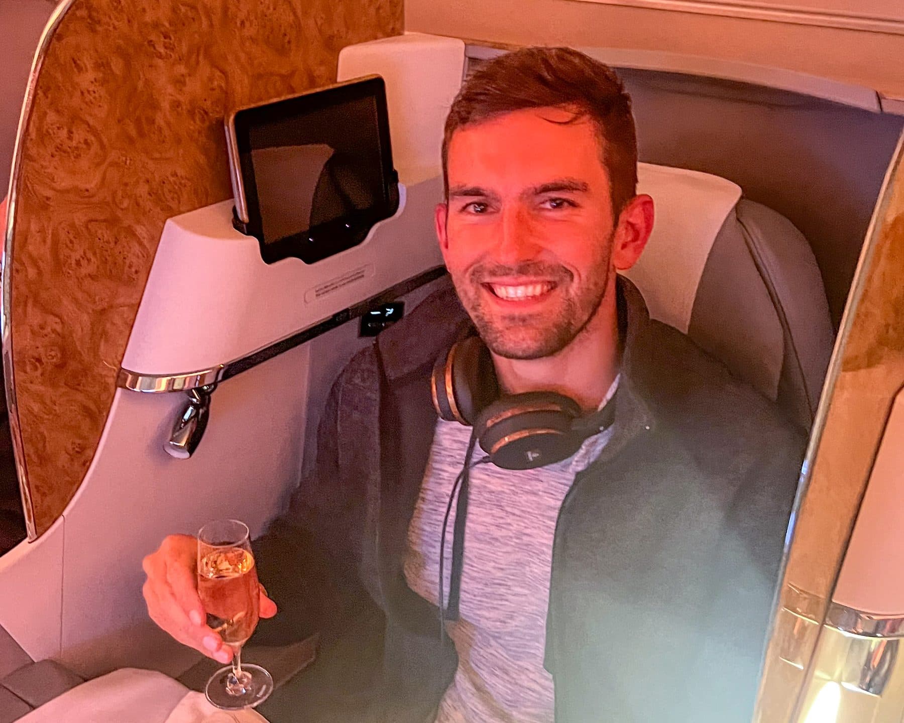 Jon Miksis seated in an Emirates business-class suite on a flight to Europe